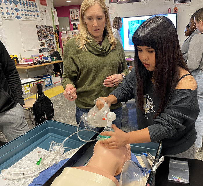 Jessica Kridler guides a student on bagmask ventilation on a mannequin