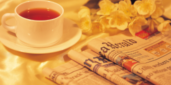 graphic featuring a cup of tea next to three newspapers laid out on a table