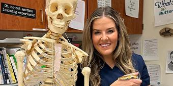 Andrea poses with a science classroom anatomical skeleton