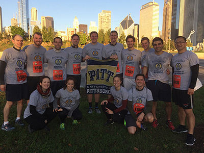 "Doctors Vogt and Sakai with CBY students in a group photo wearing department shirts and running shorts"