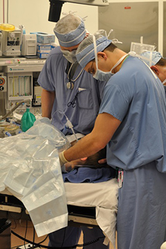 "Two medical professionals administering anesthesia to a young patient"