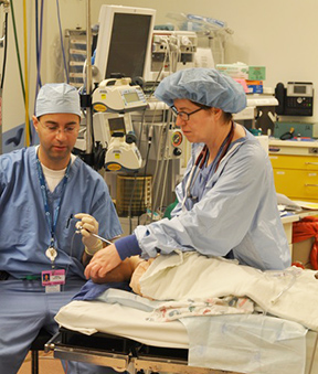 "Two medical professionals surrounded by technological equipment"