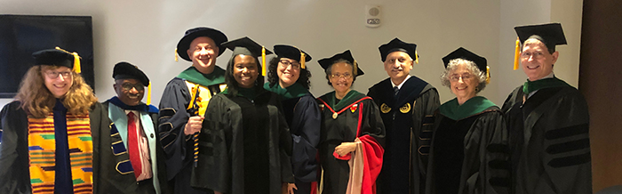 "A group of department members in graduation regalia"