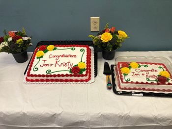 "Two cakes that say Congratulations Jen and Kristy"