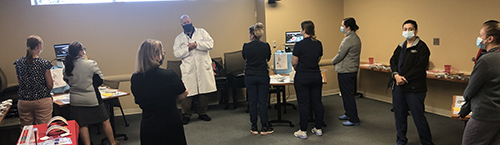 "Dr. Nick Baker with surgical APPs in the Ethicon VATS simulator station"