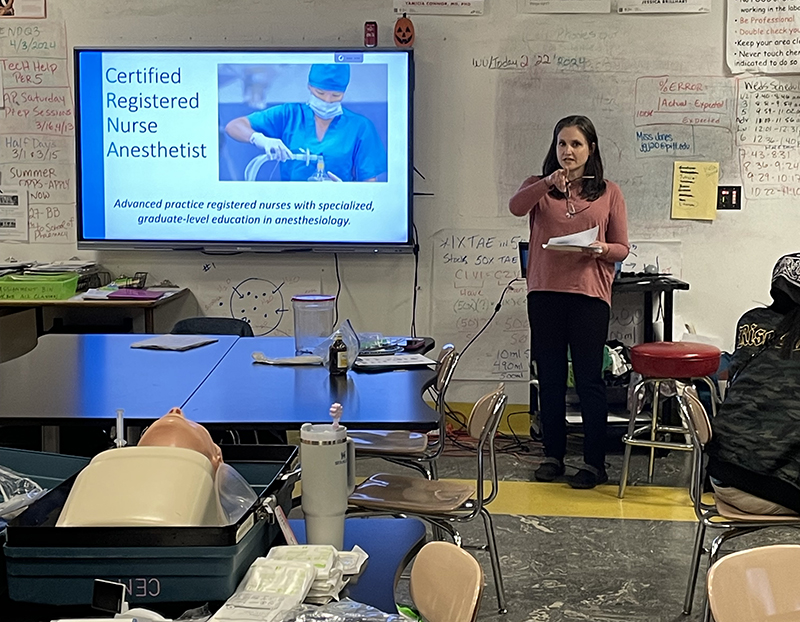 Rachel Hicks standing at the front of the classroom lecturing to students about CRNA careers