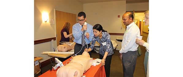 "A group of people with a training dummy"