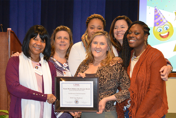 "A group of six women pose with an award"