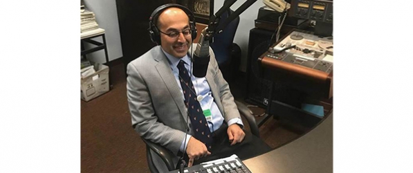 "A man in front of a microphone in a sound booth"