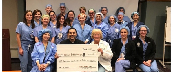 "A group of CRNAs posing with a large check"