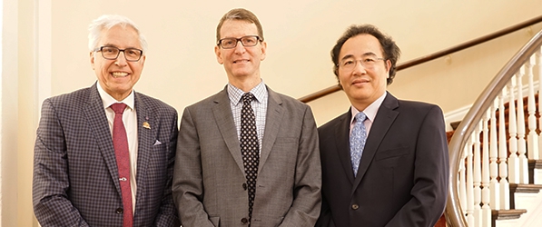 "Kochanek, Nelson, and Xu posing in front of a staircase"