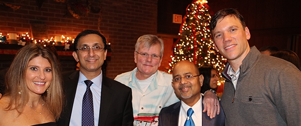 "A group poses with holiday decorations in the background"