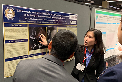 "Annie Xu presenting and pointing to a photo on her poster"