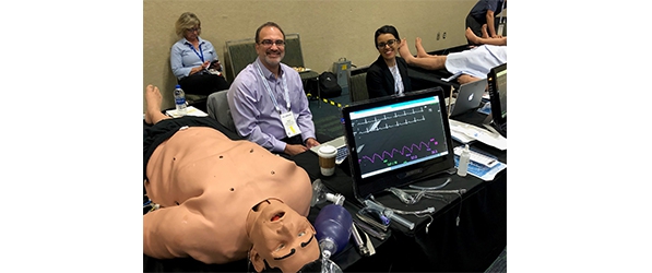 "Department members smile for a photo surrounded by medical equipment and training dummies"