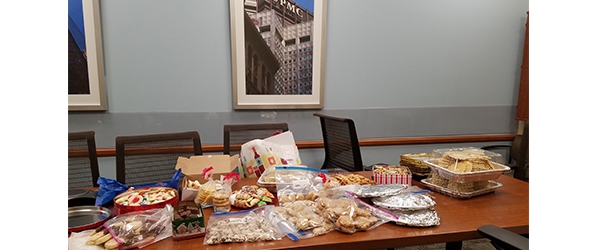 "A table covered in bags and boxes of various baked goods"