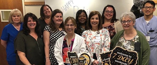 "Tina Blem surrounded by group with retirement-themed party favors"