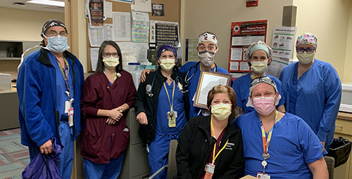 "Doctor Licata poses with team and award"