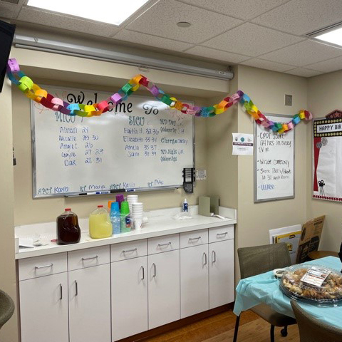 "A photo of a staff breakroom with refreshments, notes of encouragement, and a rainbow paper chain hanging on the wall"