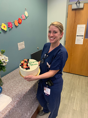 "Maria de Venecia posing in scrubs with a cake"