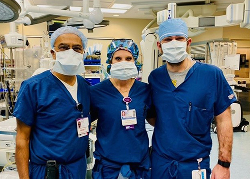 "Three medical professionals pose in a hospital lab"