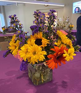 "A bouquet of flowers on a purple topped table"