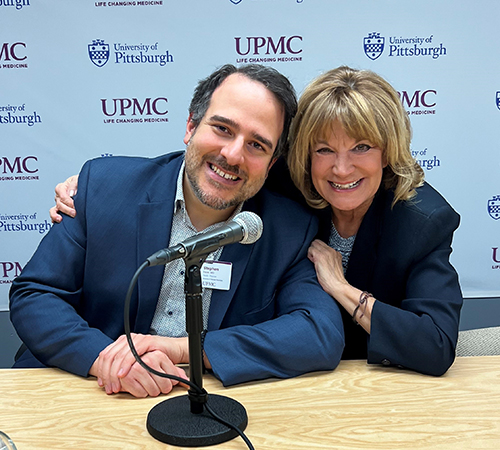 "Doctor Esper with Kathy Svilar at table with microphone"