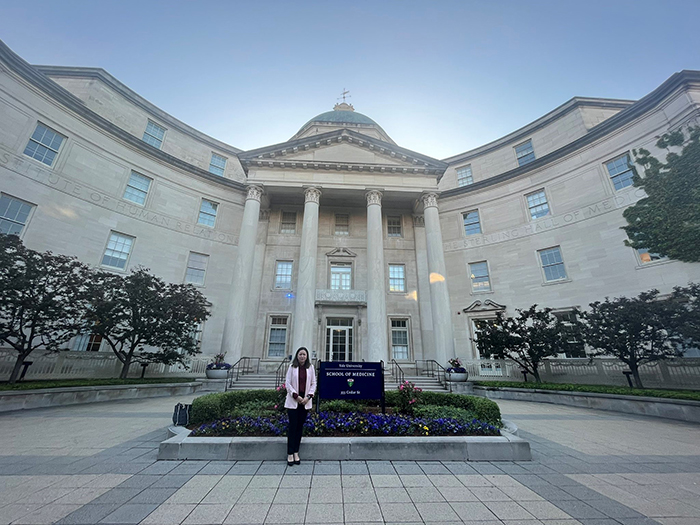 "Doctor Ibarra standing next to a sign in front of a building"