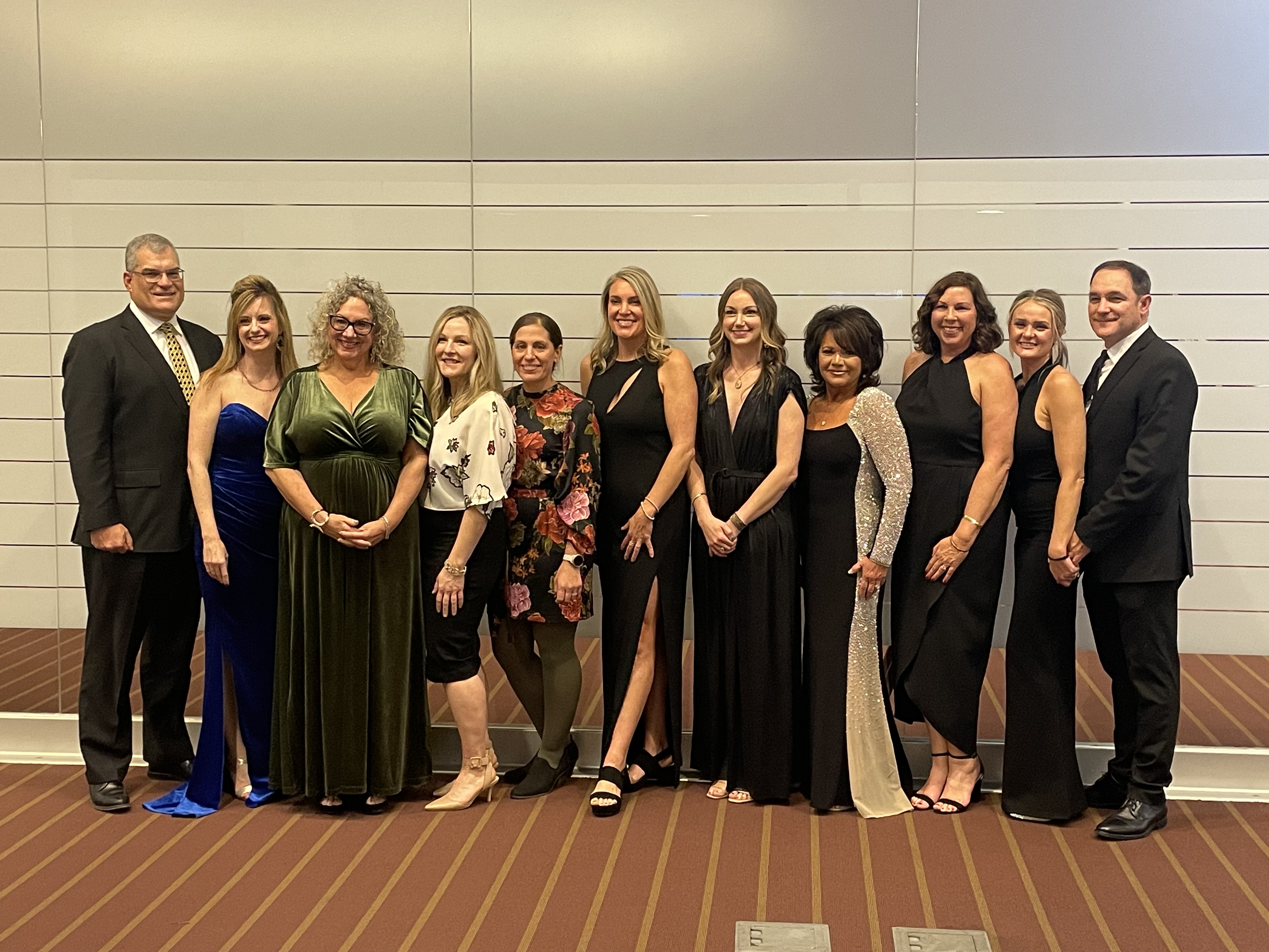 "A group of people from the UPMC team poses in formal wear"