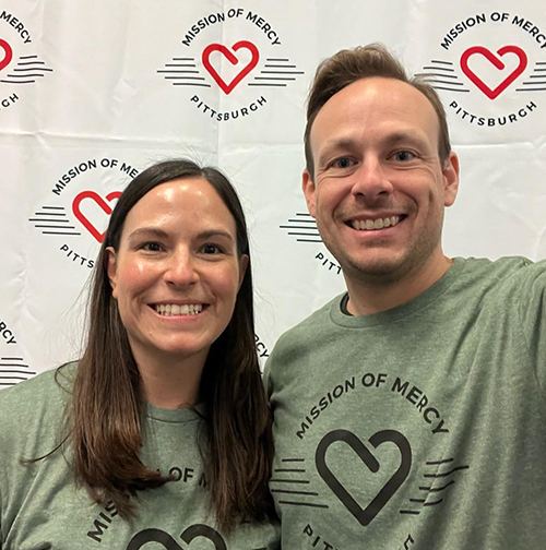 "Two department members take a selfie wearing Mission of Mercy Pittsburgh shirts"