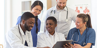 A group of physicians looking at a laptop