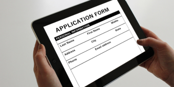 Graphic featuring a person holding a tablet to submit an application form