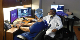 two physicians reviewing data on a computer