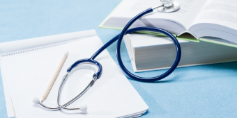 stethoscope on medical books and a notepad