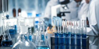 test tubes with two scientists working in the background