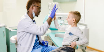 physician giving a high-five to a pediatric patient