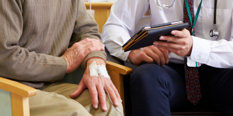 patient sitting with a physician discussing clinical issues