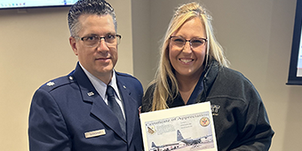 Lt Col Giordano presenting Dani with a personal certificate of appreciation and a challenge coin that was flown over Afghanistan in the final days of the war.