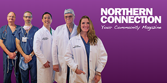 A group of five medical professionals stand in a row wearing scrubs and white lab coats. They are smiling and looking directly at the camera. The background is purple with the text "NORTHERN CONNECTION Your Community Magazine" displayed in white and pink lettering.