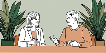 Illustration of a woman and a man sitting at a table, engaged in a friendly conversation. Both are gesturing with their hands, facing each other, and smiling. The background features green potted plants against a light green wall, creating a relaxed and professional setting.