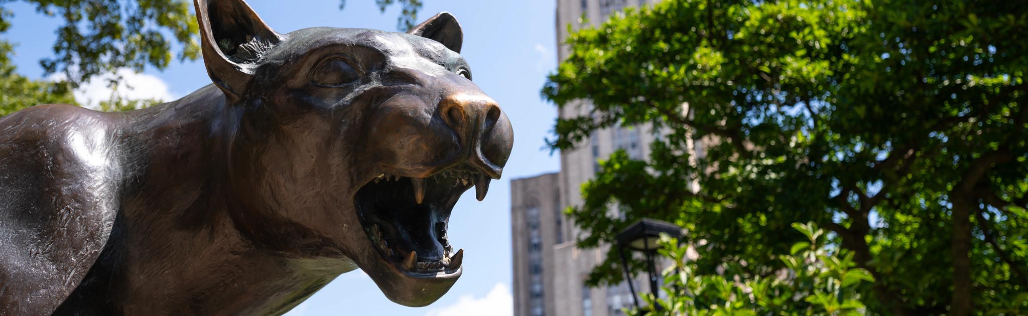 Pitt panther with the cathedral of learning in the background